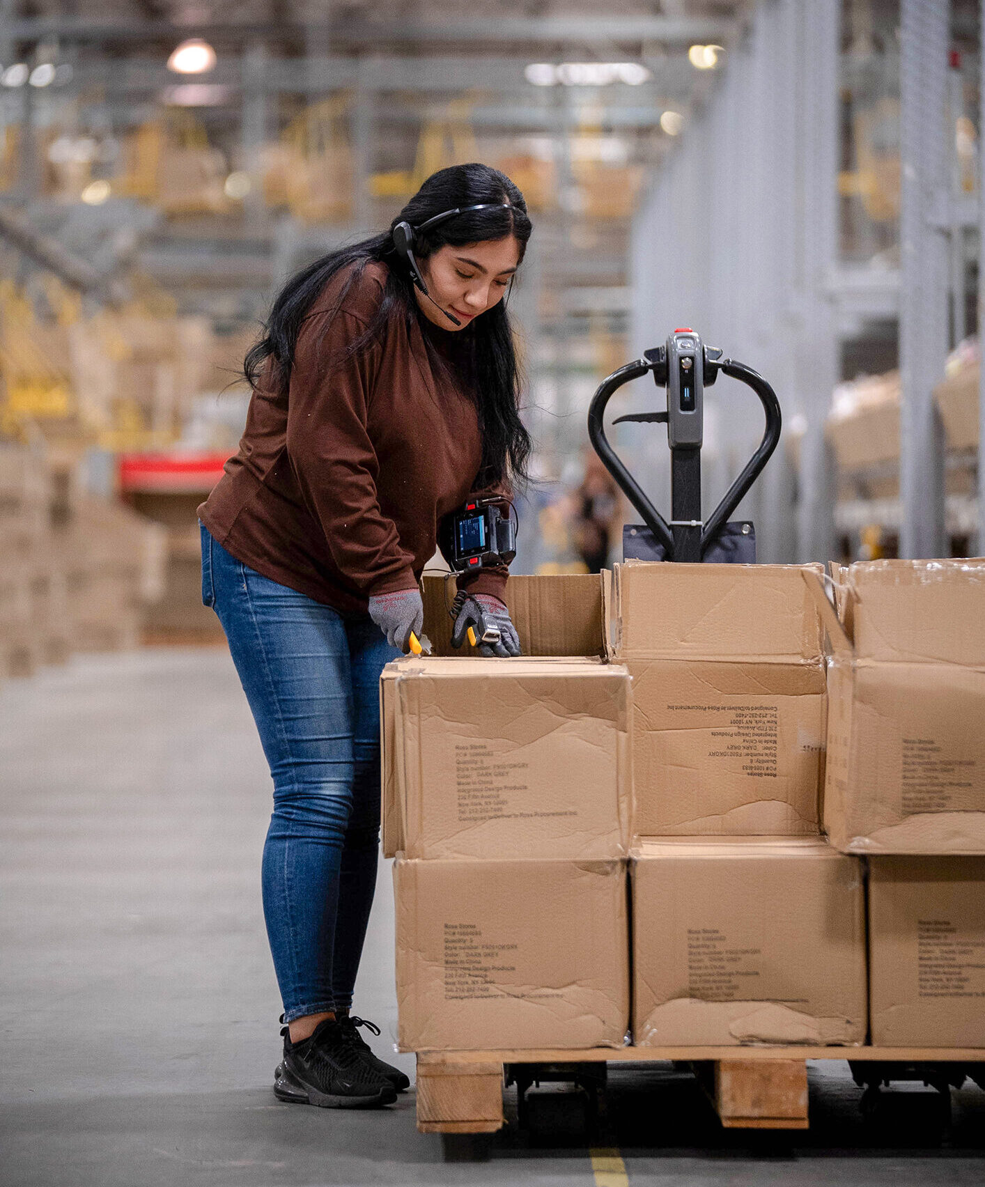 Associate opening boxes of inventory at a distribution center.